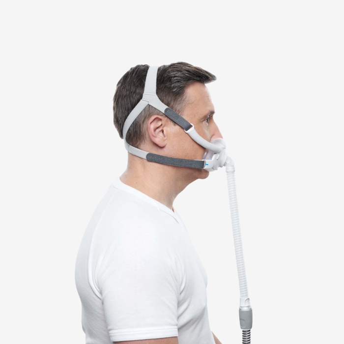 Man wearing a CPAP ResMed F40 mask with a white background