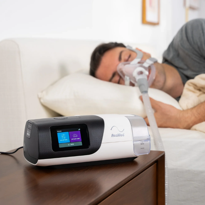 Man using ResMed AirSense 11 sleep apnea CPAP machine with advanced sleep therapy features.